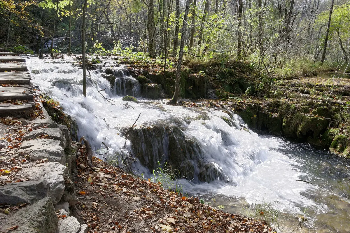 Water rushing past a wooden boardwalk