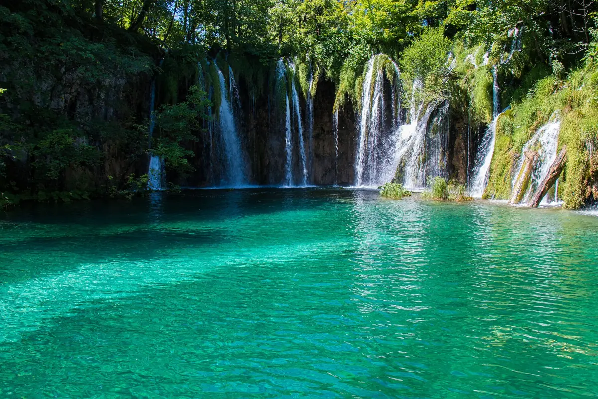 Waterfalls pouring into a turquoise lake at Plitvice